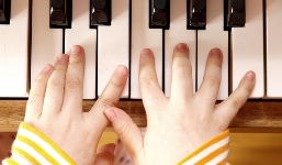 Child's Hands on Piano Keyboard